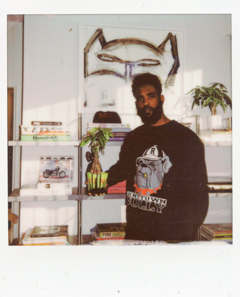 Franklin Thompson holding a Money Tree plant in his studio.