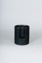 Black self watering pot uses absorbent thread and a water reservoir to deliver water to the plant&